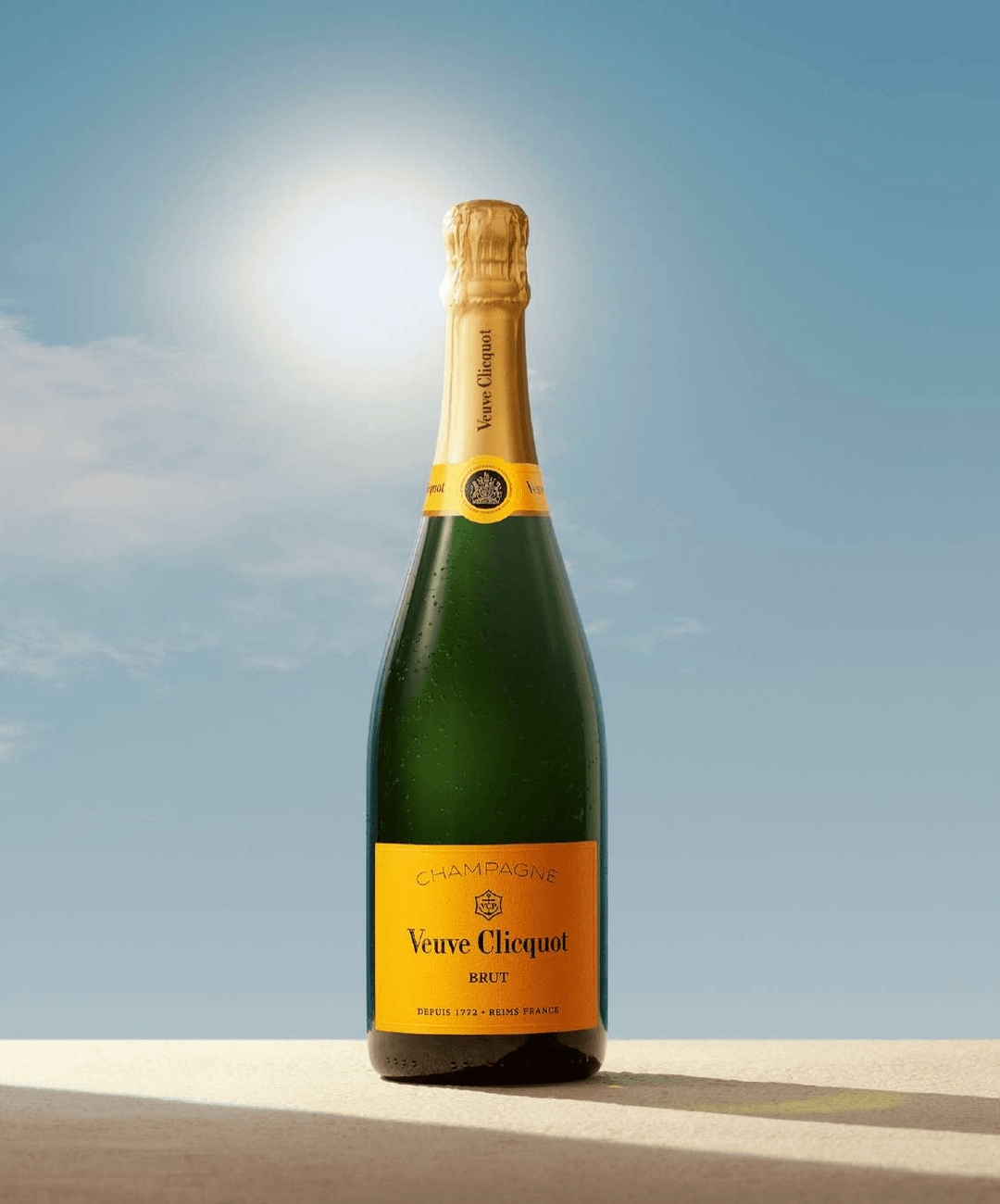 Butelka szampana Veuve Clicquot Brut na tle błękitnego nieba